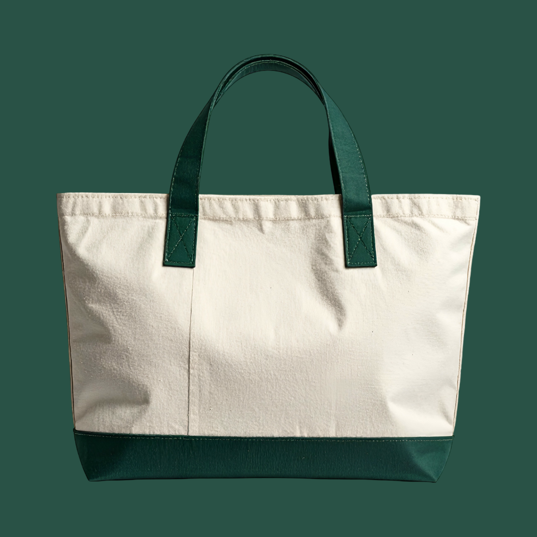 Canvas tote bag with cream body and forest green leather handles